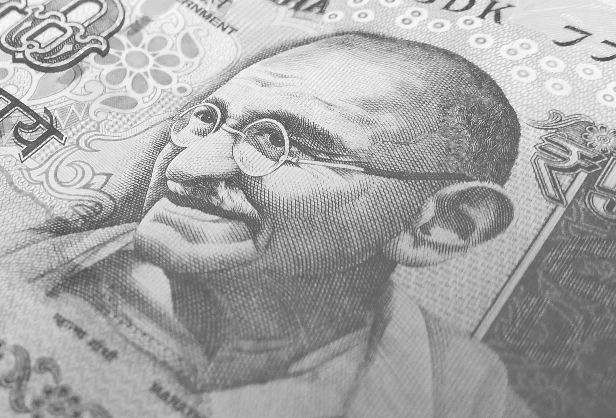 Detailed monochrome depiction of an Indian rupee banknote with Gandhi's portrait, symbolizing finance and economy.